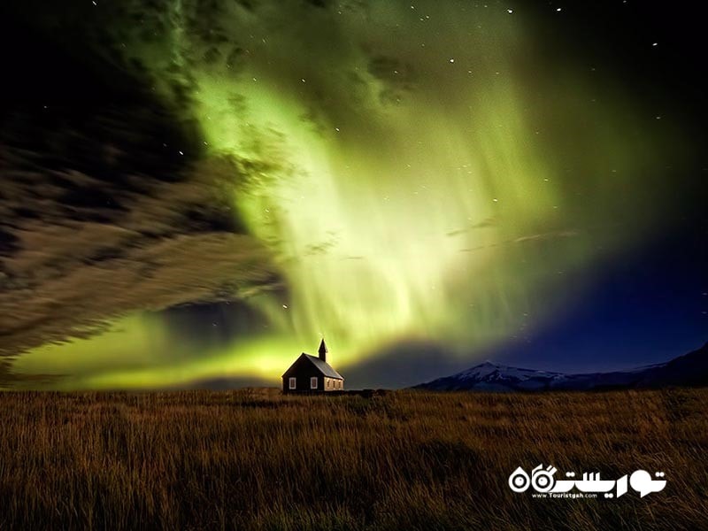 تصویری از شفق قطبی (Aurora Borealis) در نزدیکی یک کلیسا