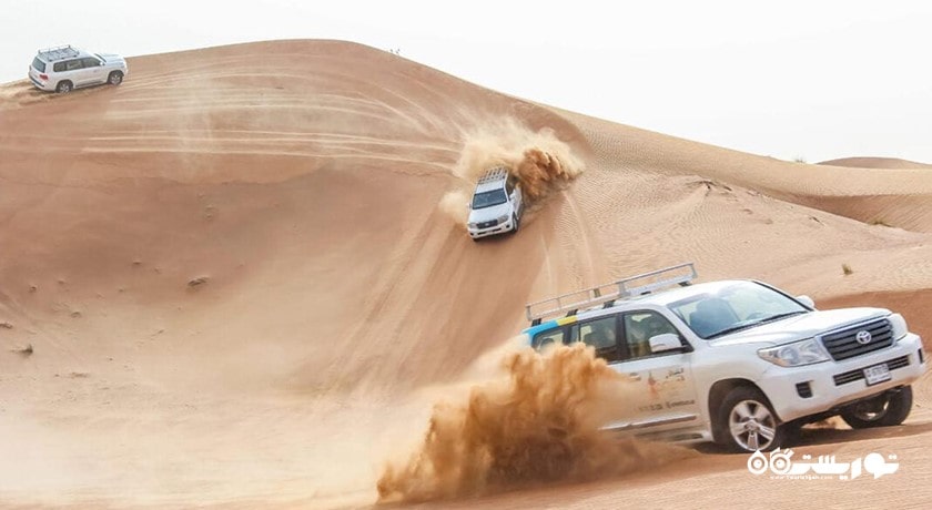 سرگرمی سواری با خودروی شاستی بلند در تپه های شنی شهر امارات متحده عربی کشور ابوظبی