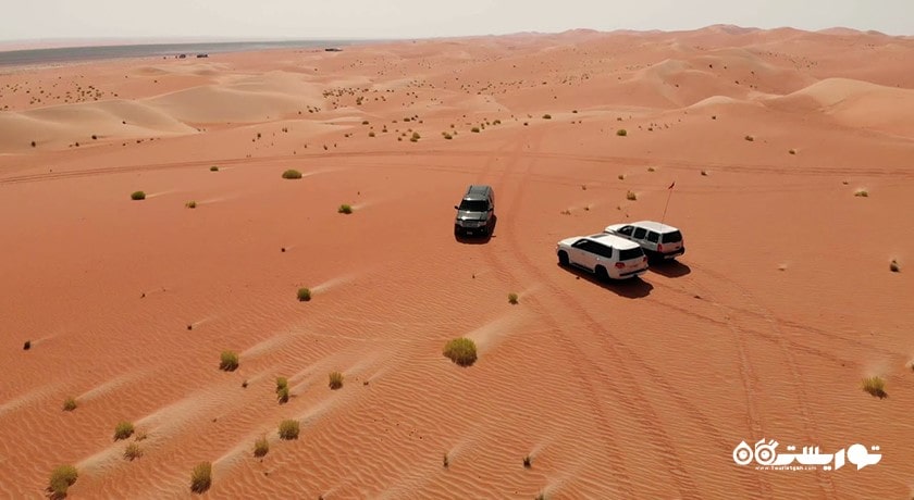 سرگرمی سواری با خودروی شاستی بلند در تپه های شنی شهر امارات متحده عربی کشور ابوظبی