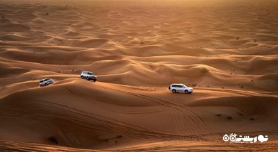 سرگرمی سواری با خودروی شاستی بلند در تپه های شنی شهر امارات متحده عربی کشور ابوظبی